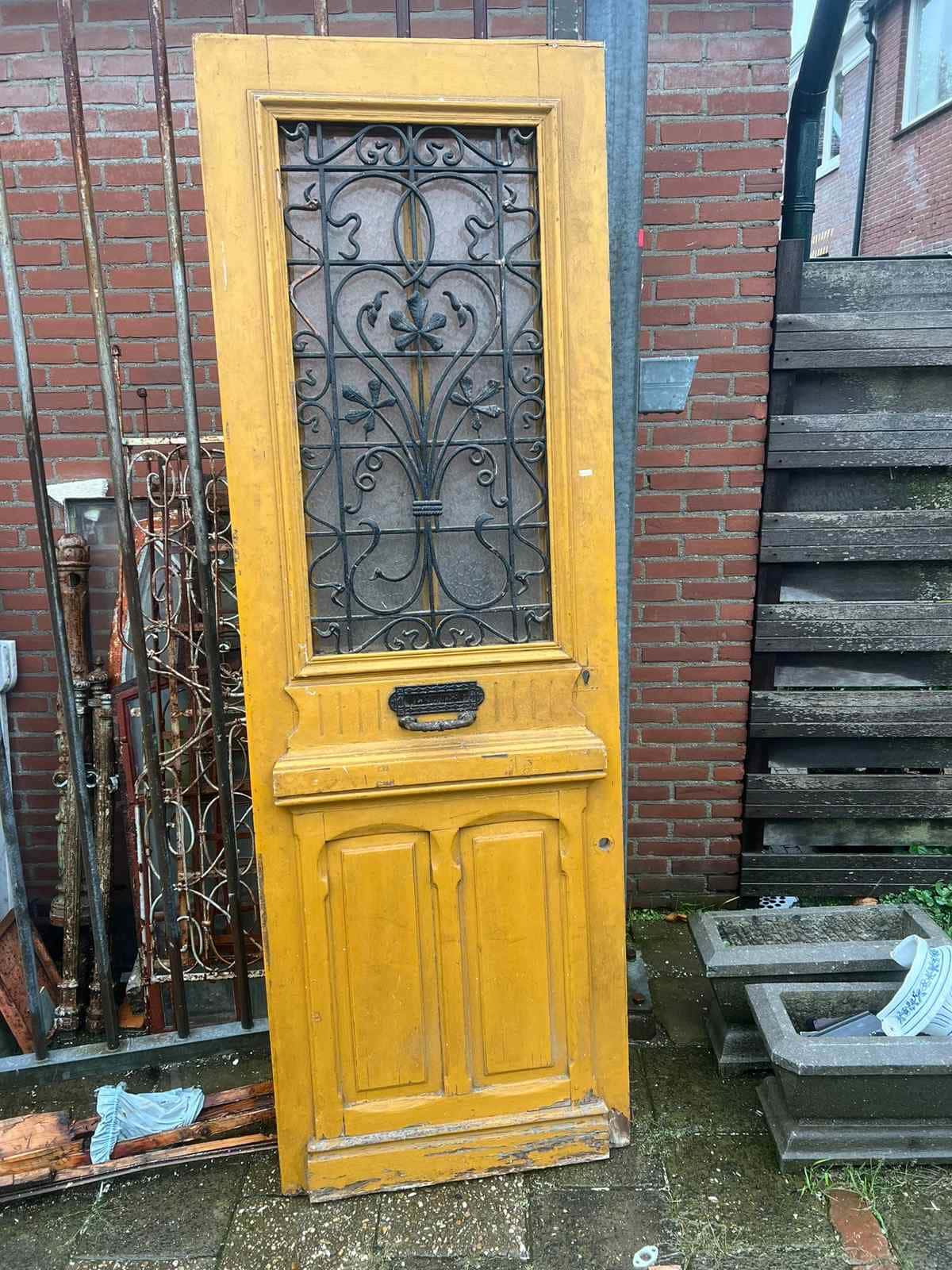 Antieke voordeur met gietijzeren rooster